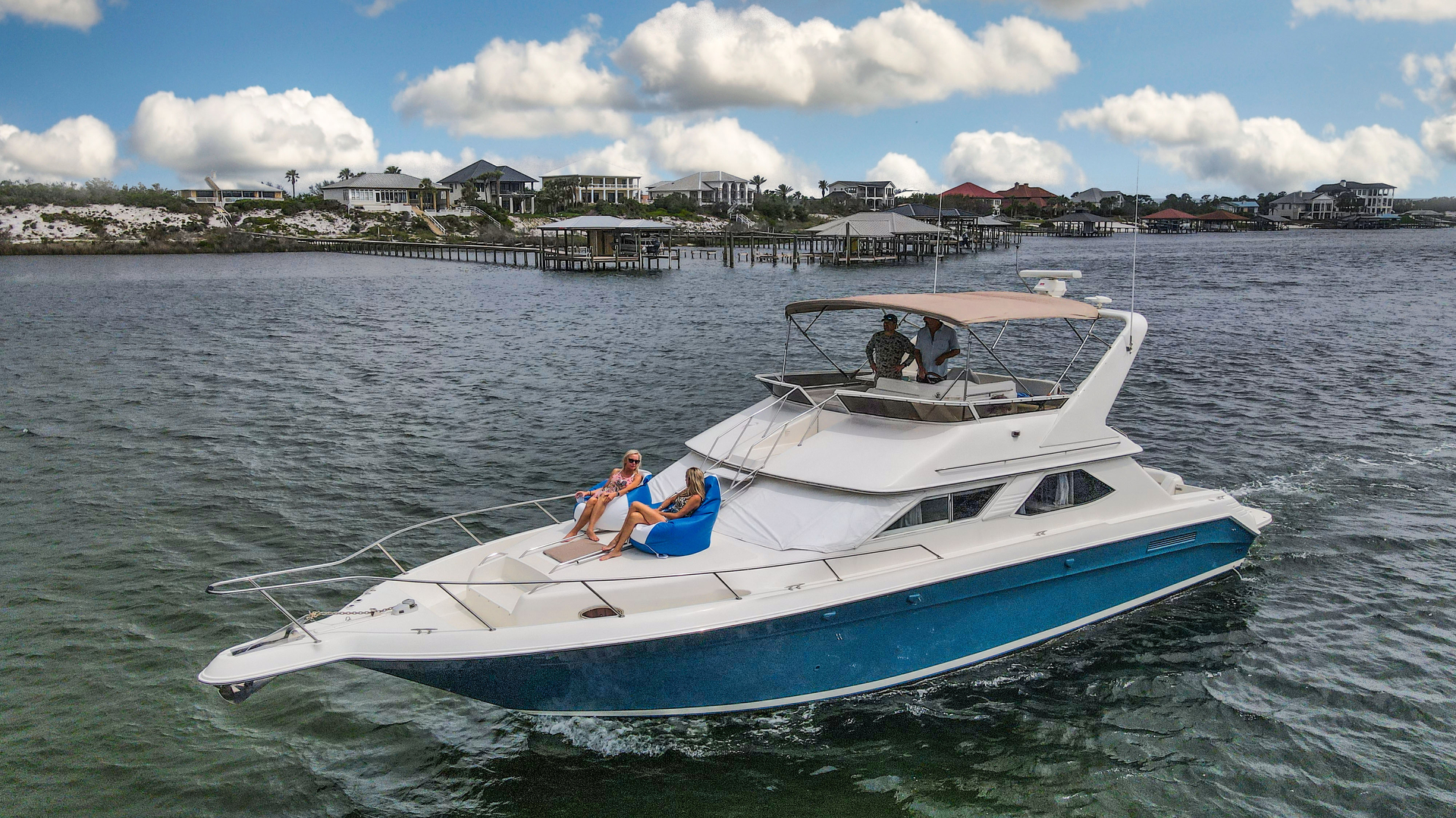 A sleek yacht cruising on calm waters with a clear sky.